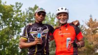 Two Cyclists holding beverages