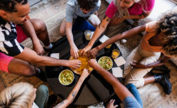 People reach for snacks on a table