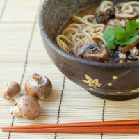 Mushrooms Sitting Next to Bowl of Mushroom Miso Ramen